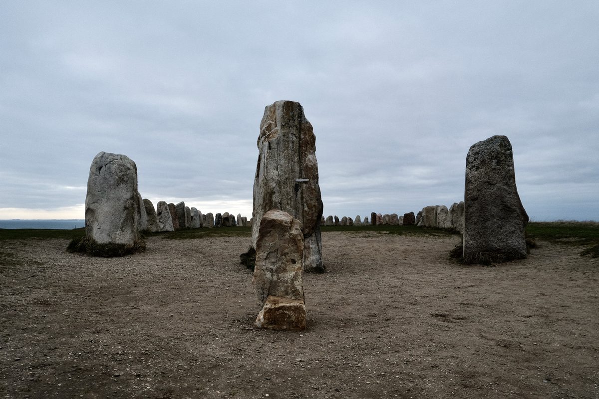 Ales Stenar stone ship in Kåseberga, Sweden, with large standing stones arranged in a ship formation under a grey cloudy sky.