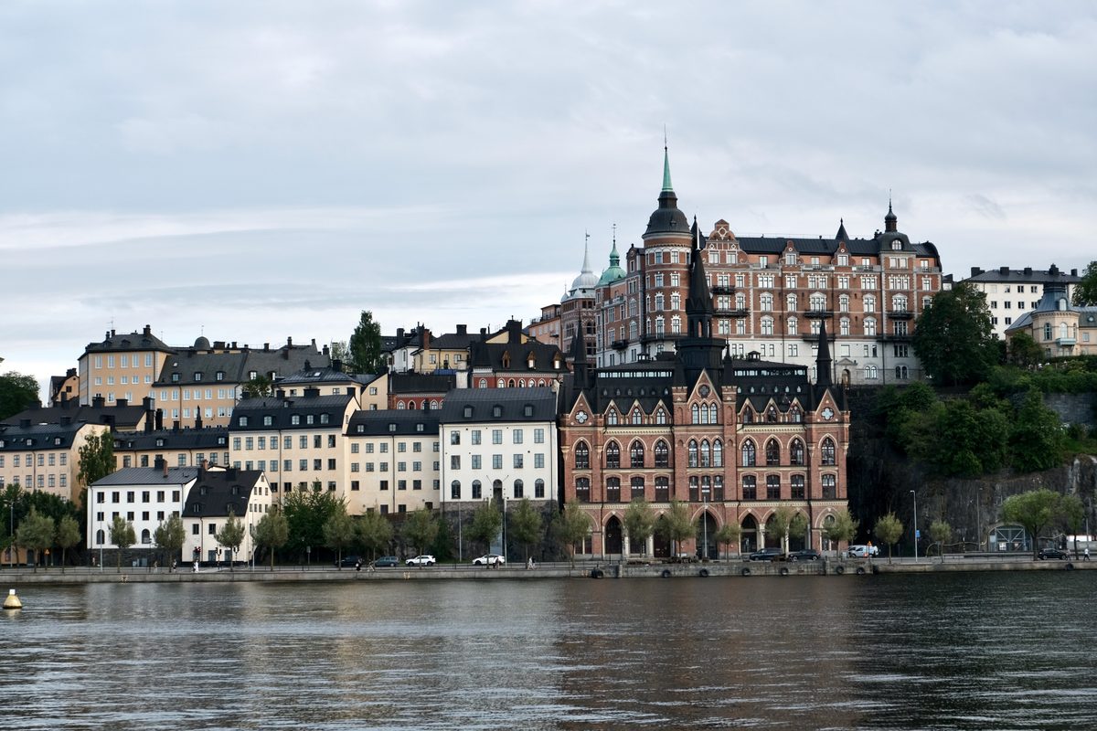 A waterfront view from Södra Riddarholmshamnen in Stockholm, looking across the water toward Söder Mälarstrand and Mariahissen, with historic buildings rising above the shoreline.